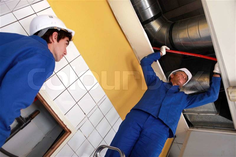 Workers working on air conditioning, stock photo