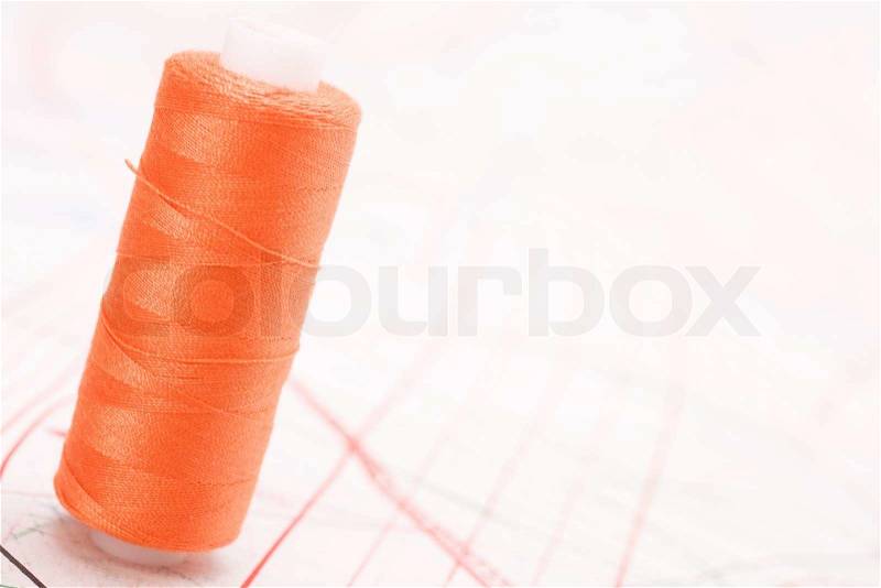 Spool of thread. Sew accessories on blurred background, stock photo