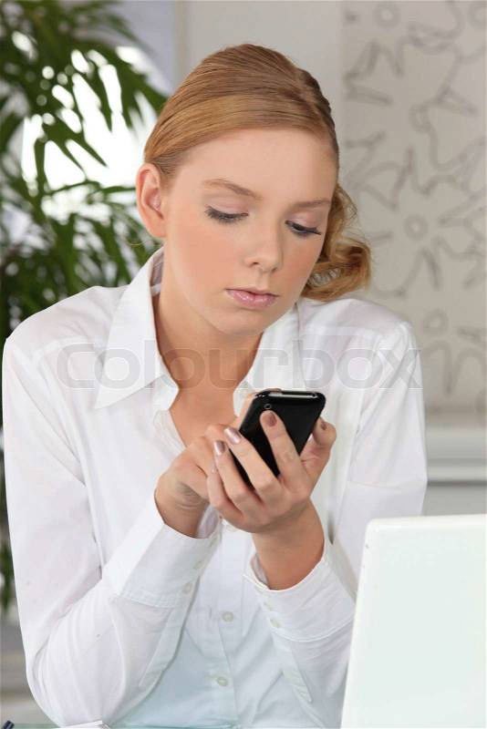 Young fair-haired woman sending text message, stock photo