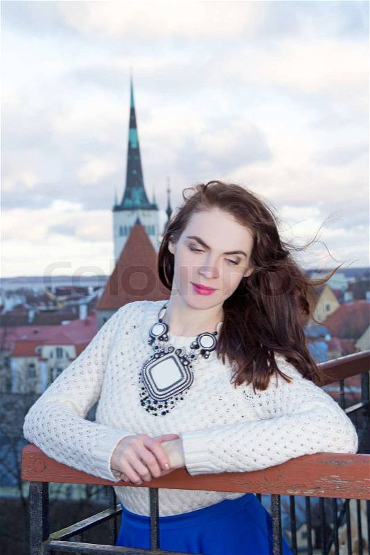 Young dreaming woman looking down at the city of Tallinn, stock photo