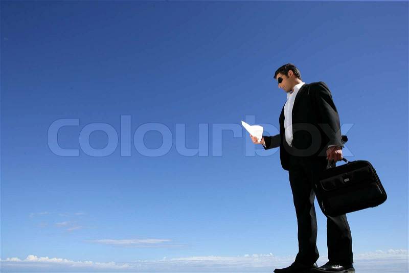 Businessman with a briefcase against a blue sky, stock photo