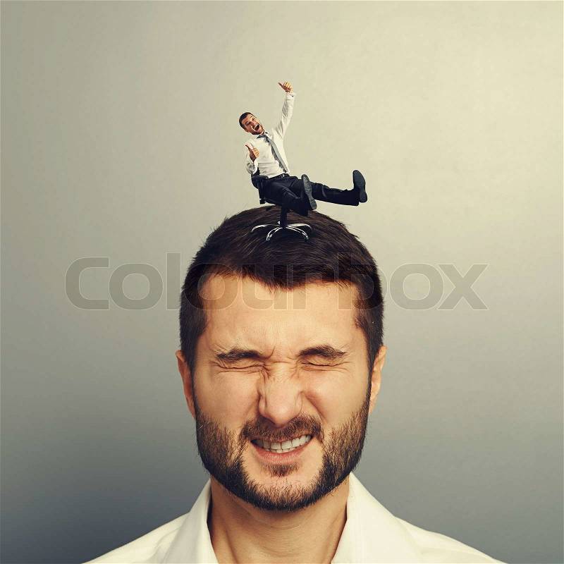 Crazy man rolling on the head of another man, stock photo