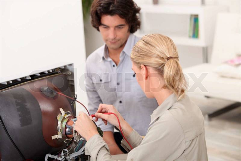Couple repairing old television, stock photo