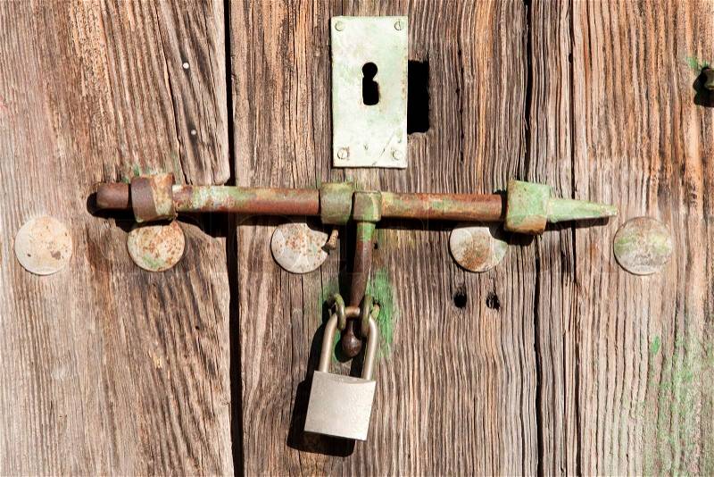 Old wooden door shut with an old rusty lock and padlock, stock photo
