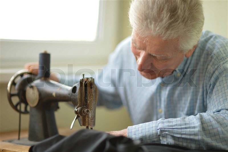 Man working at sewing machine, stock photo