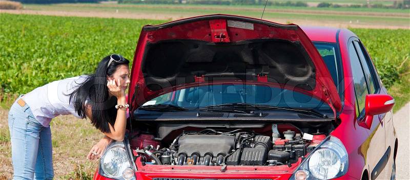 Young woman breaks down in her car. engine failure, stock photo