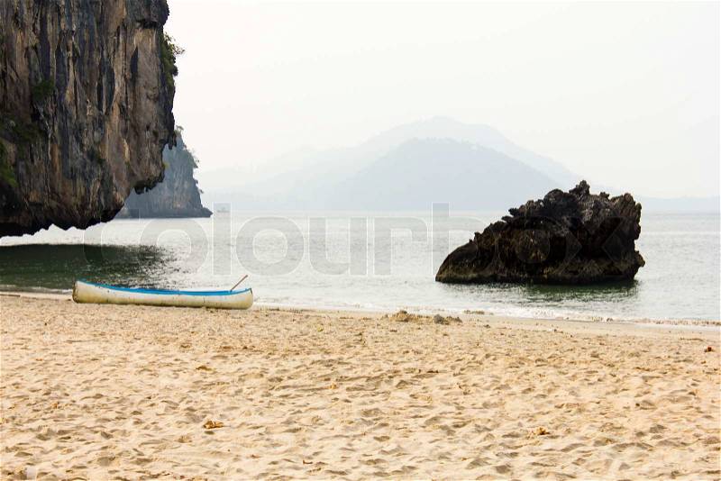 Outrigger of blue canoe on the beach, stock photo