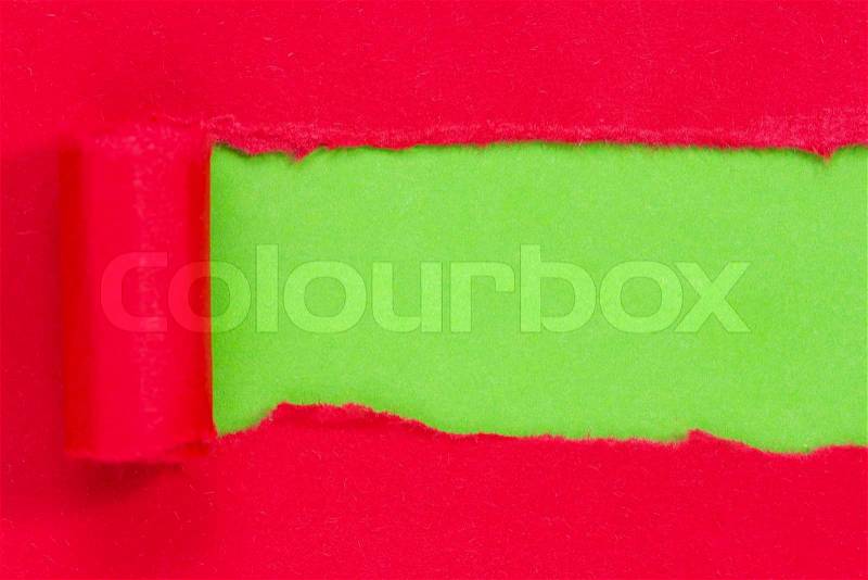 Red paper torn to reveal green panel ideal for copy space, stock photo