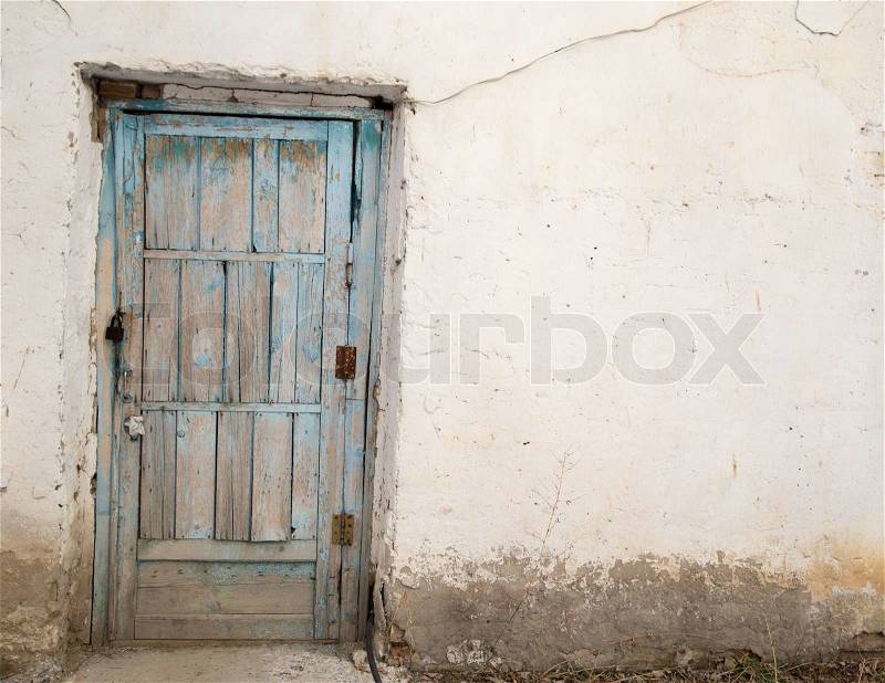 Old wooden door on a white wall, stock photo