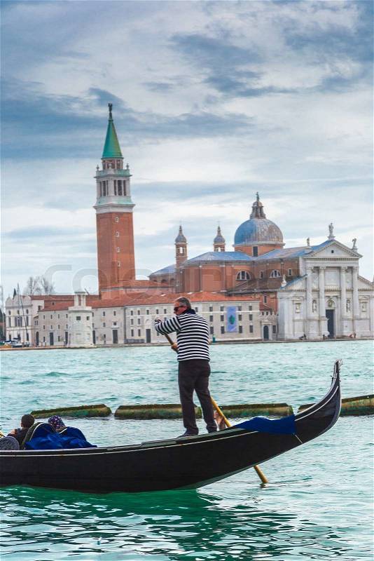 ITALY, VENICE - FEB 7: Gondolier on a gondola on the Grand Canal on February 7, 2013 in Venice. Gondola\'s are a major mode of touristic transport in Venice, Italy, stock photo