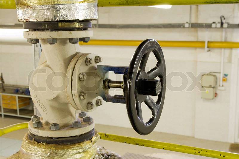 Steam pipe with a valve in the boiler room, stock photo