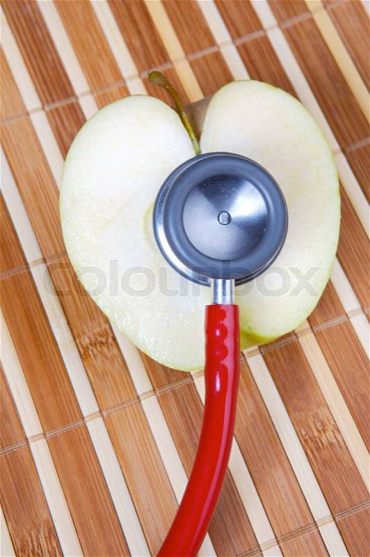 Stethoscope and apple (a healthful food and heals), stock photo