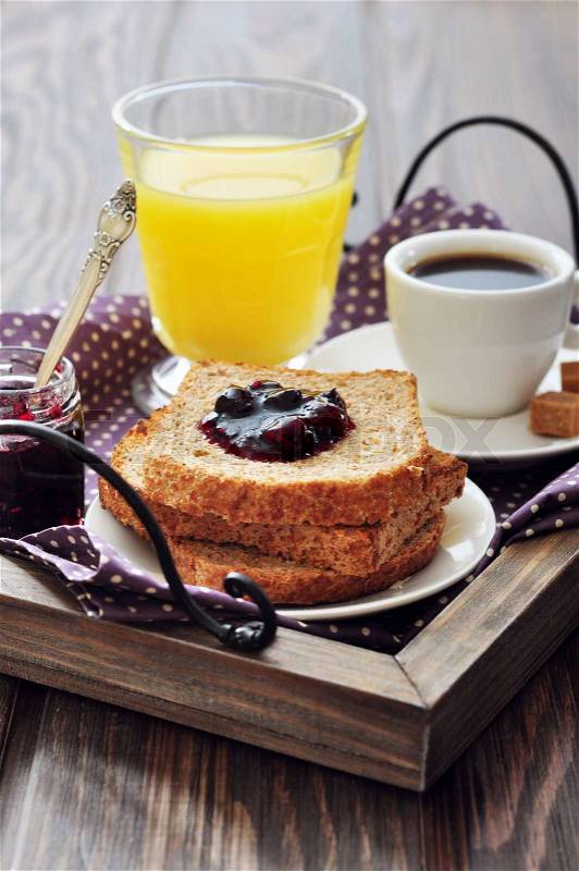Breakfast with toast, fruit jam, orange juice and coffee on tray, stock photo