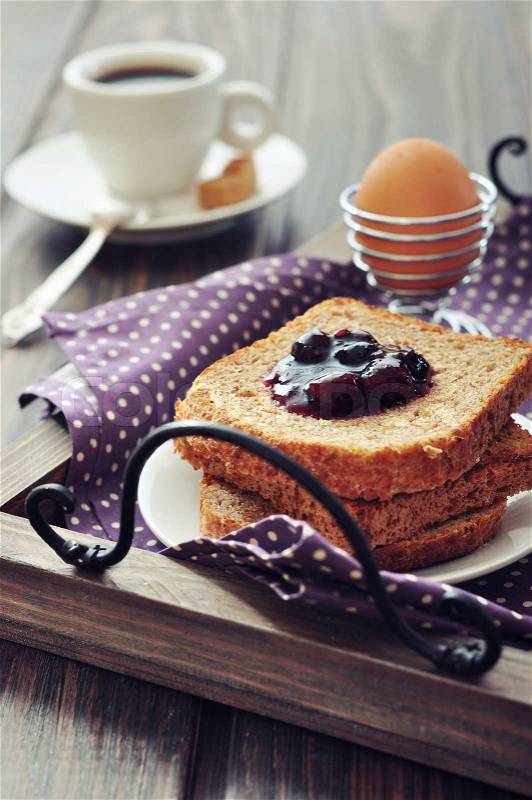 Breakfast with toast, fruit jam, boiled egg and coffee on tray, stock photo
