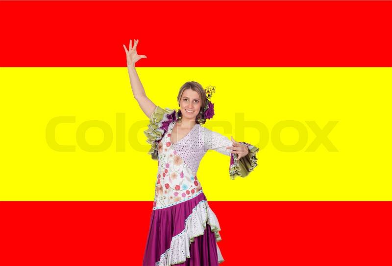 Spanish girl dressed in traditional costume Andalusian dancing on a over red and yellow background, stock photo