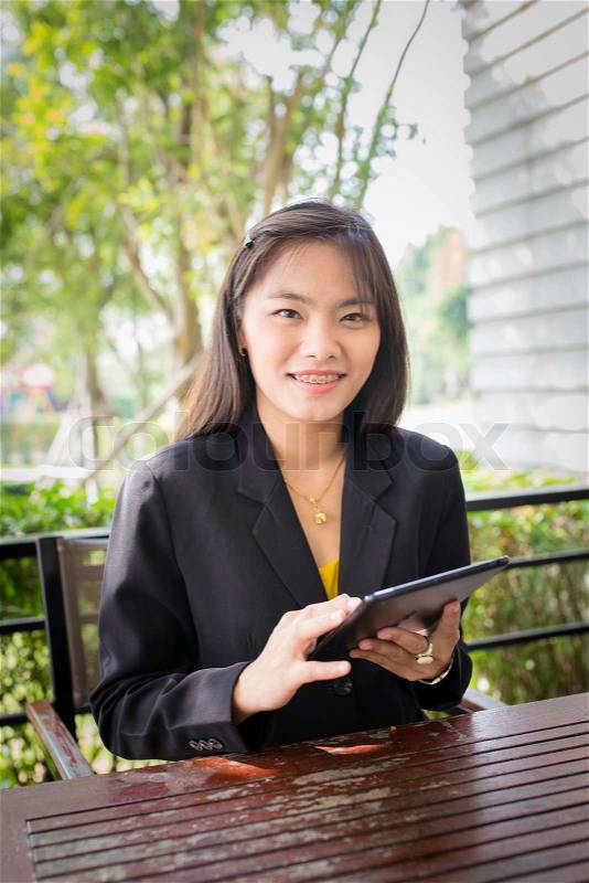 Beautiful Asian business woman using tablet for communication, stock photo