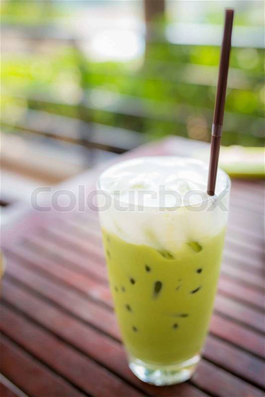 Green tea smoothie on wooden table, natural backdrop, stock photo