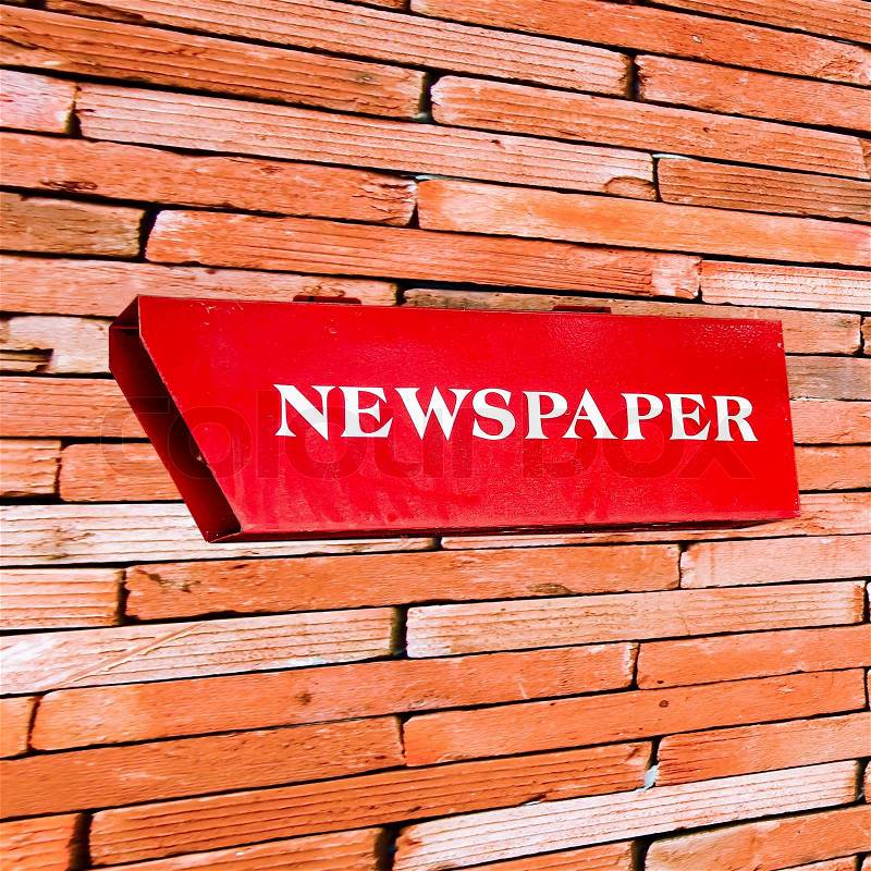 Newspaper box on brickwall, stock photo