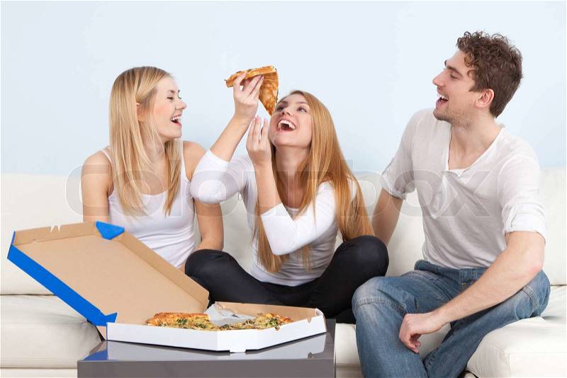Group of young people eating pizza at home, stock photo