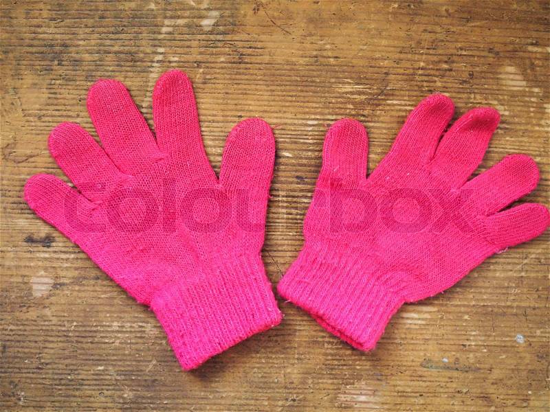 Pink gloves on a wooden table, stock photo