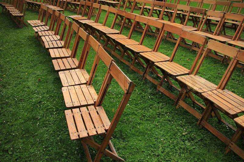 Folding chairs stand in the grass in the open air waiting for the coming people for the next performance, stock photo