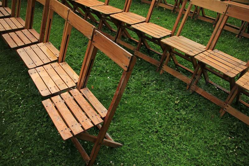 Coming performance, many empty folding chairs in the grass waiting for the people, stock photo