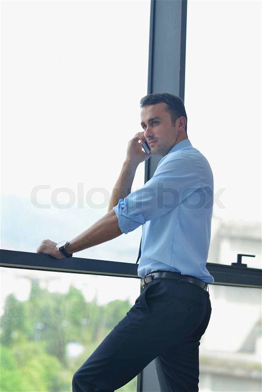 Business man talking by cellphone in office, stock photo