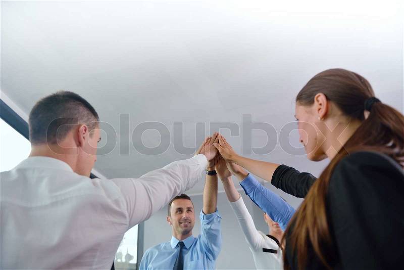 Business people group joining hands and representing concept of friendship and teamwork, low angle view, stock photo