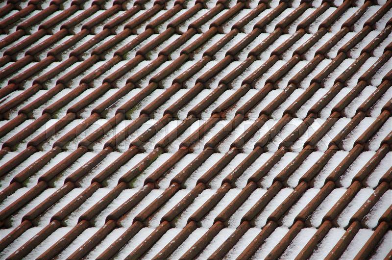 Red roof tiles with snow, stock photo