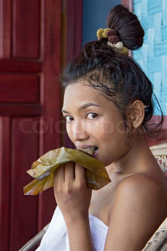 Young woman eat sticky rice steamed in banana leaf Lao style, stock photo