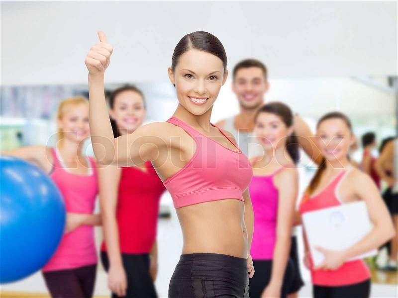 Fitness, sport, training and lifestyle concept - personal trainer with group of smiling people in gym, stock photo
