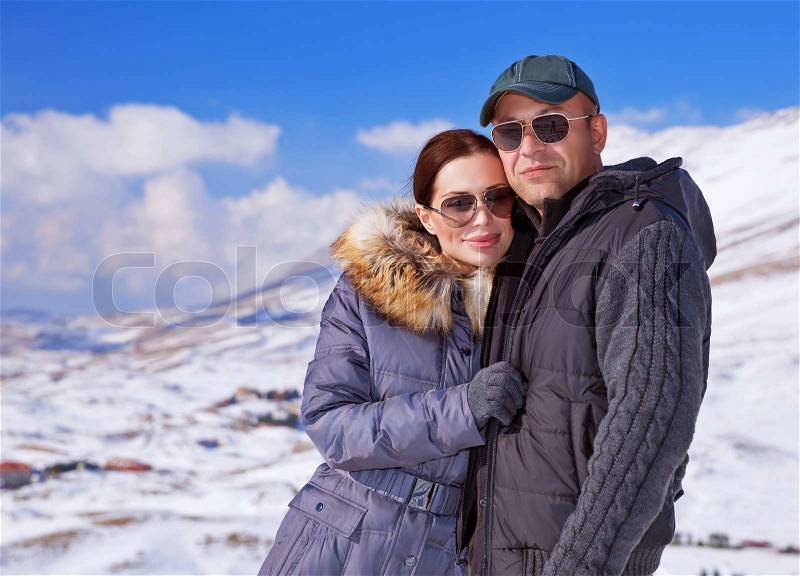 Portrait of happy couple spending winter vacation in the mountains, ski resort, cold weather, romantic relationship concept, stock photo