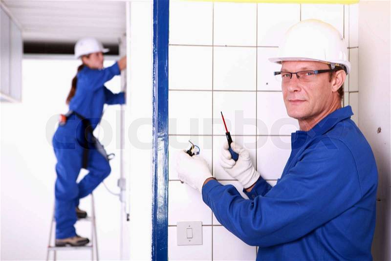 Electricians wiring a house, stock photo