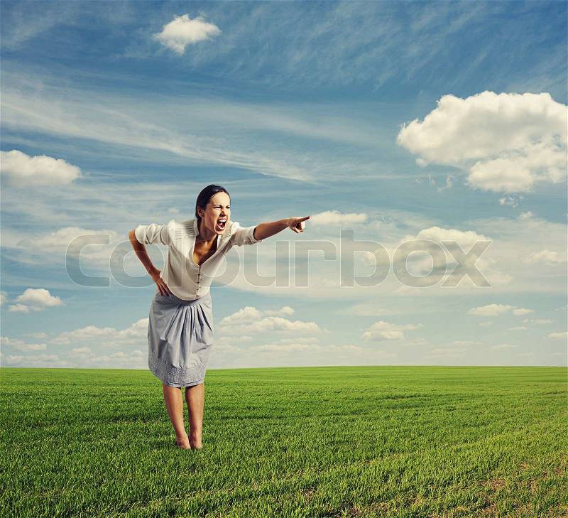 Angry woman screaming and pointing at something, stock photo