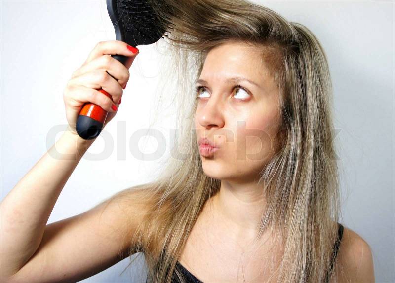 Young woman combing her long hair, stock photo