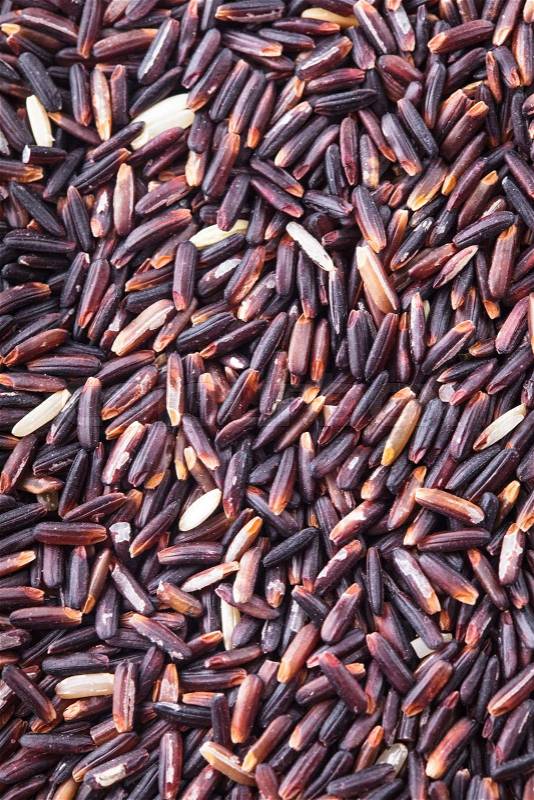 Black rice scattered as a background. Food design, stock photo