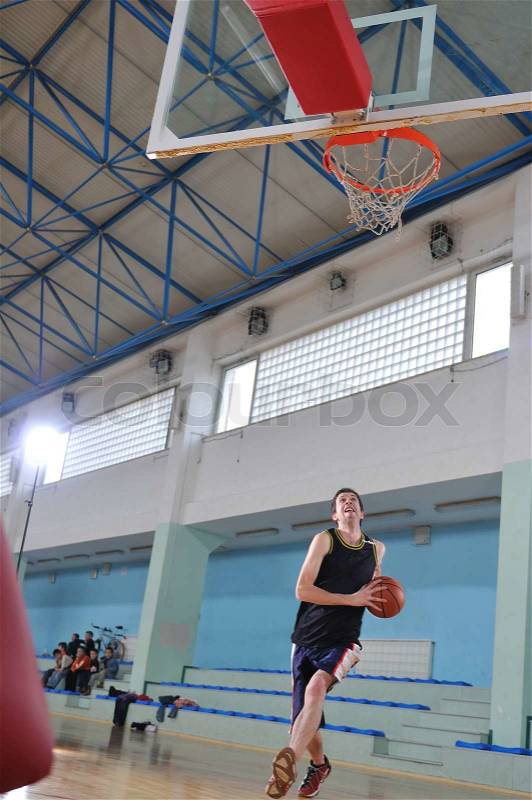 One healthy young man play basketball game in school gym indoor, stock photo