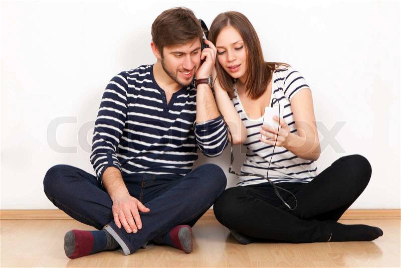Two people listening to music together, stock photo