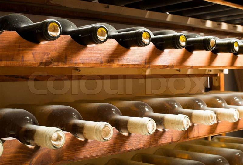 Wine bottles on shelf. Wine cellar. Close up wine bottles, stock photo