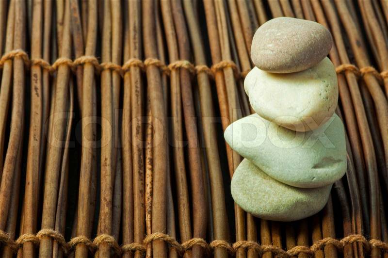 Stacked stones on wooden base. Studio shot, stock photo