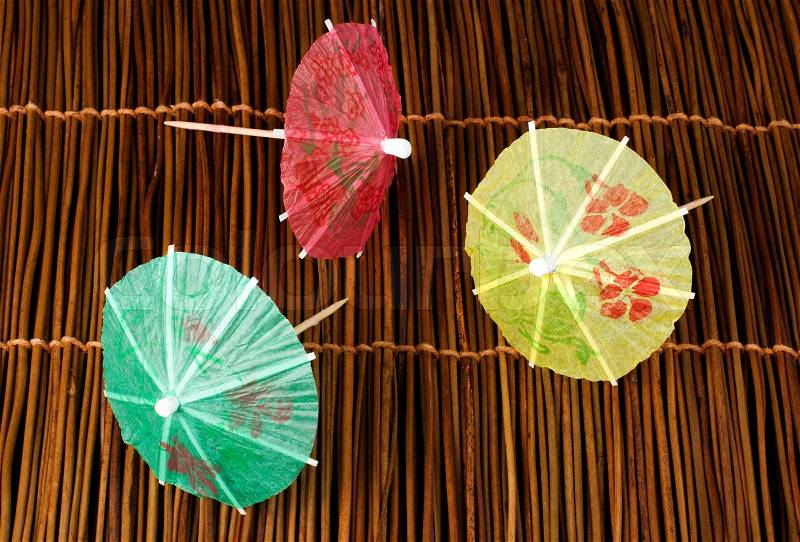Colorful cocktail umbrellas on wooden base. Close up , stock photo