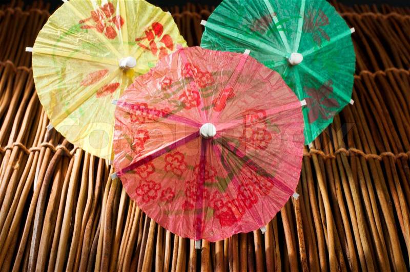 Colorful cocktail umbrellas on wooden base. Close up , stock photo