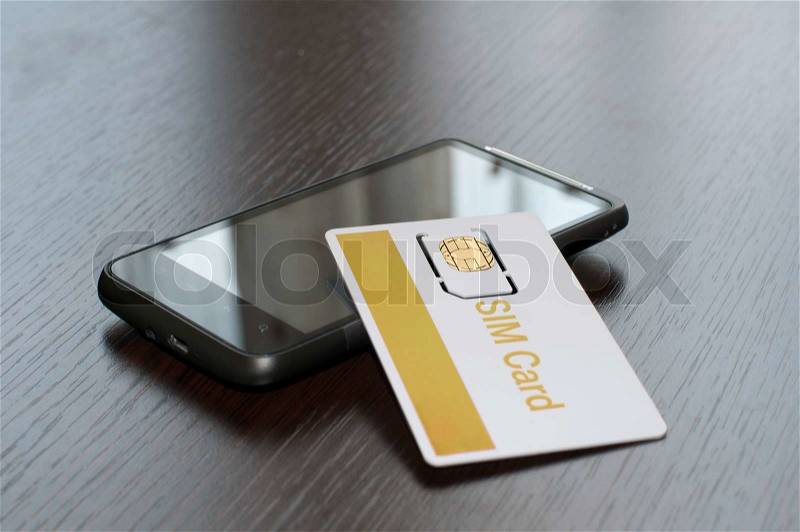 SIM card and mobile phone on table, stock photo