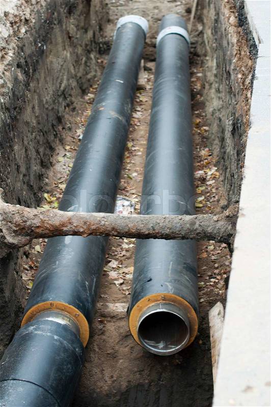 Installing pipes for hot water and steam heating. City heat pipeline, stock photo