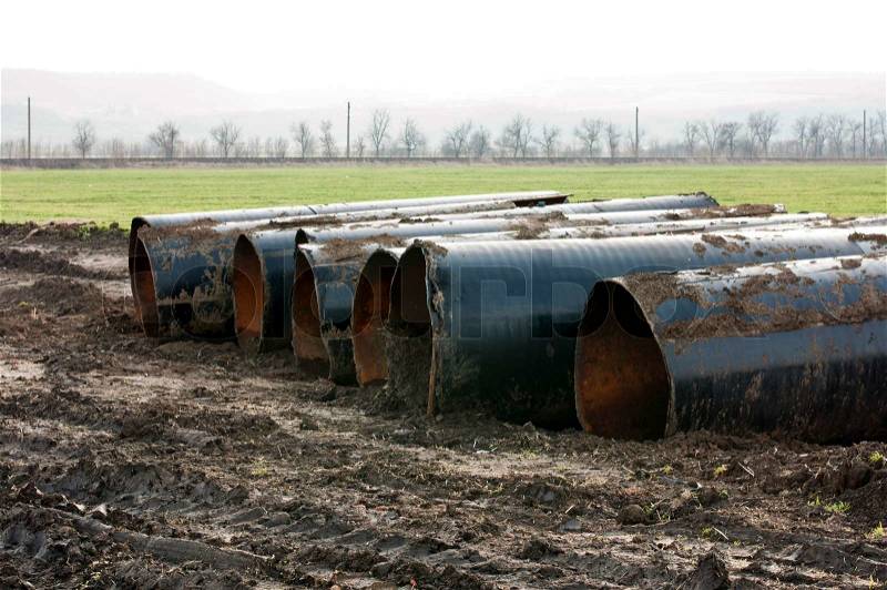 Old metal pipes dismantled for scrap placed on land, stock photo