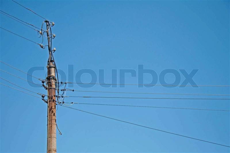 Old electrical wiring. Column on blue sky background, stock photo