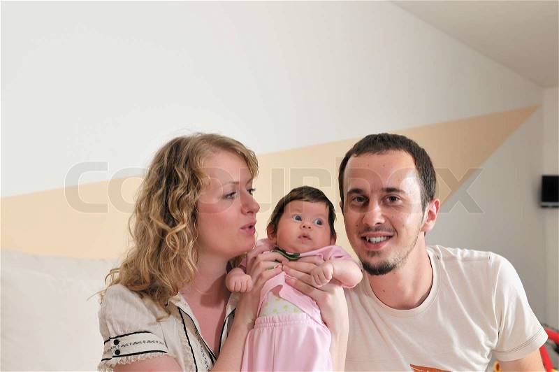 Indoor portrait with happy young family and cute little babby, stock photo
