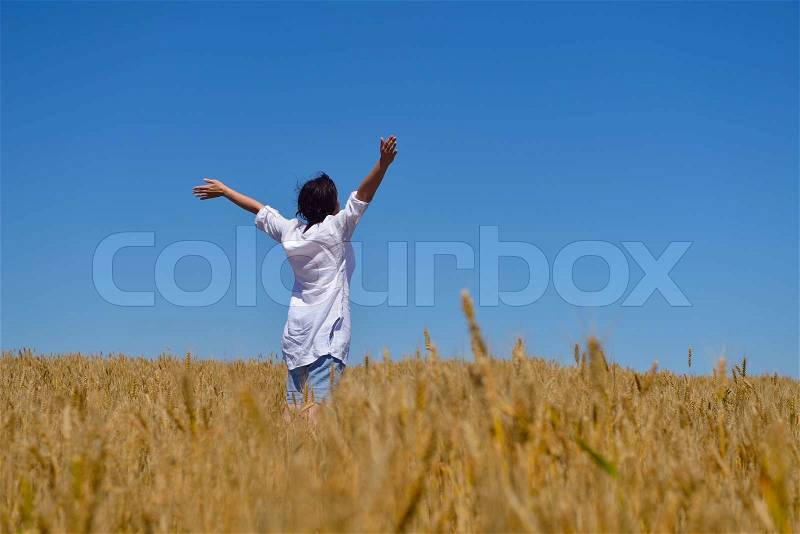 Healthy Happy young woman with spreading arms, blue sky with clouds in background - copyspace, stock photo