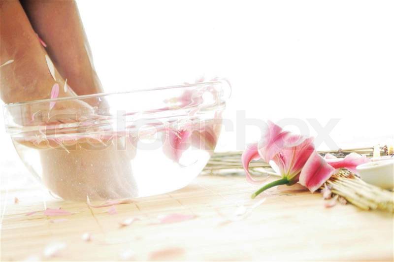 Woman spa pedicure foot treatment with water and flower, stock photo
