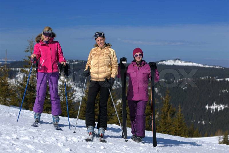 Happy friends group of woman girls have fun at winter season at beautiful sunny snow day with blue sky in background, stock photo